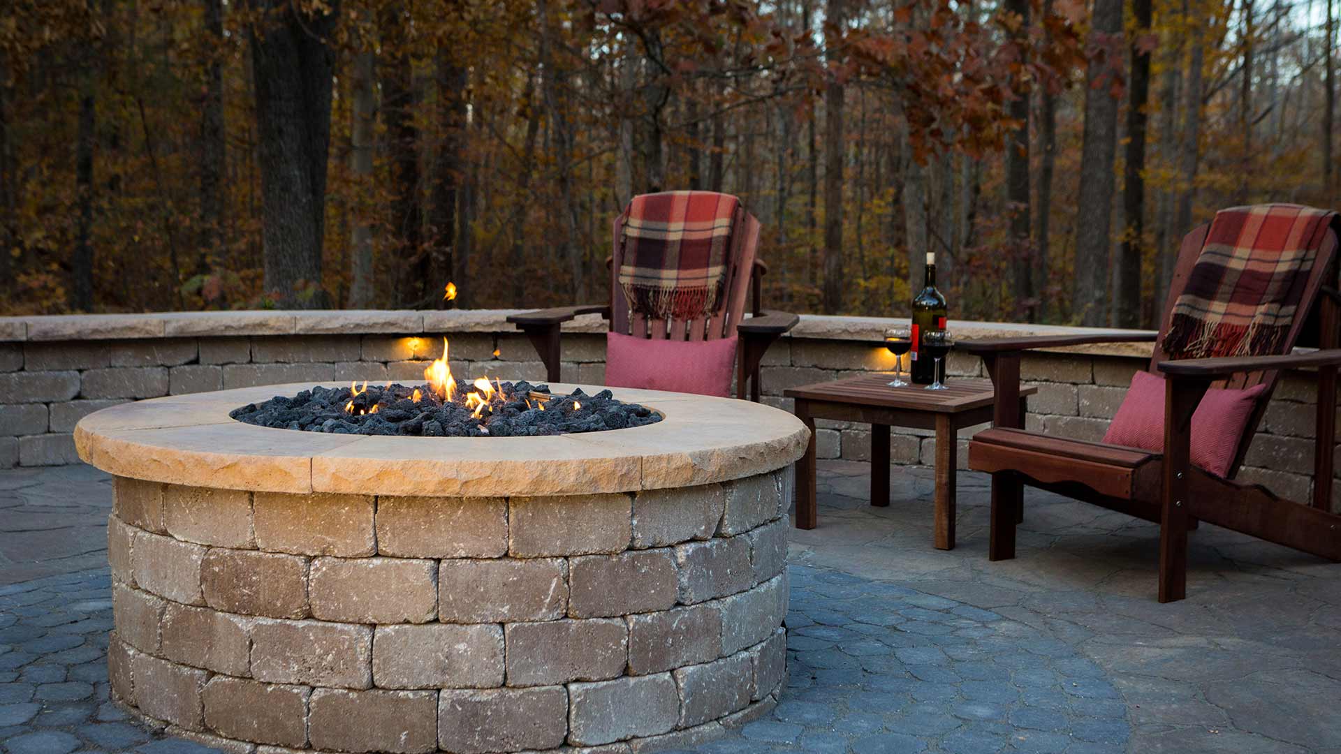 Custom fire pit and paver patio with seating and wine on table near Greensboro, NC.