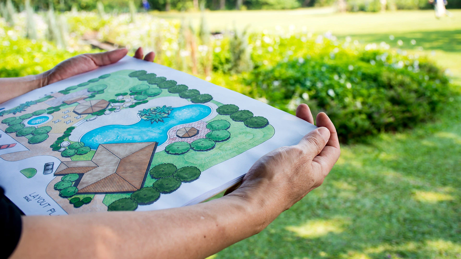 Our landscape designer holding a custom drawing for a future landscape in Gibsonville, NC.