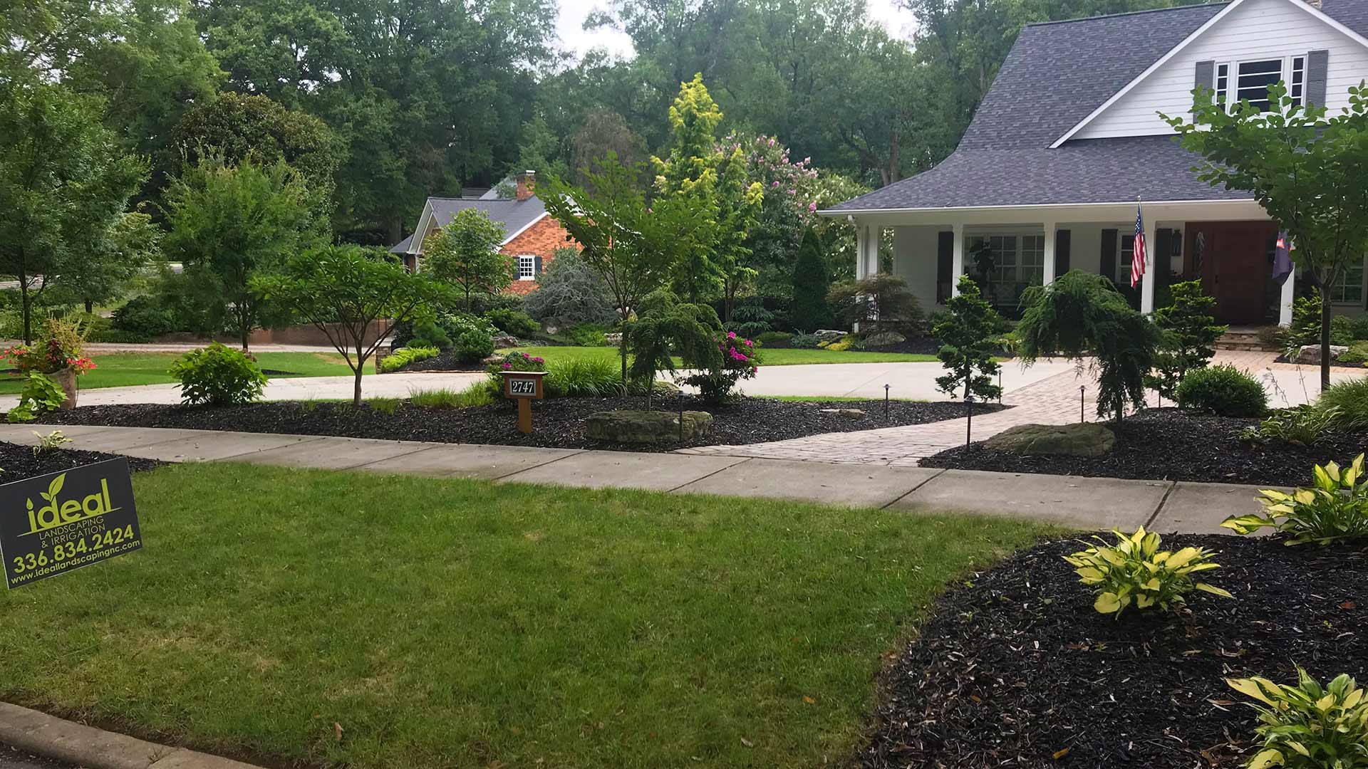Large yard with fresh mulch installation and trimmed landscape trees in Summerfield, NC.