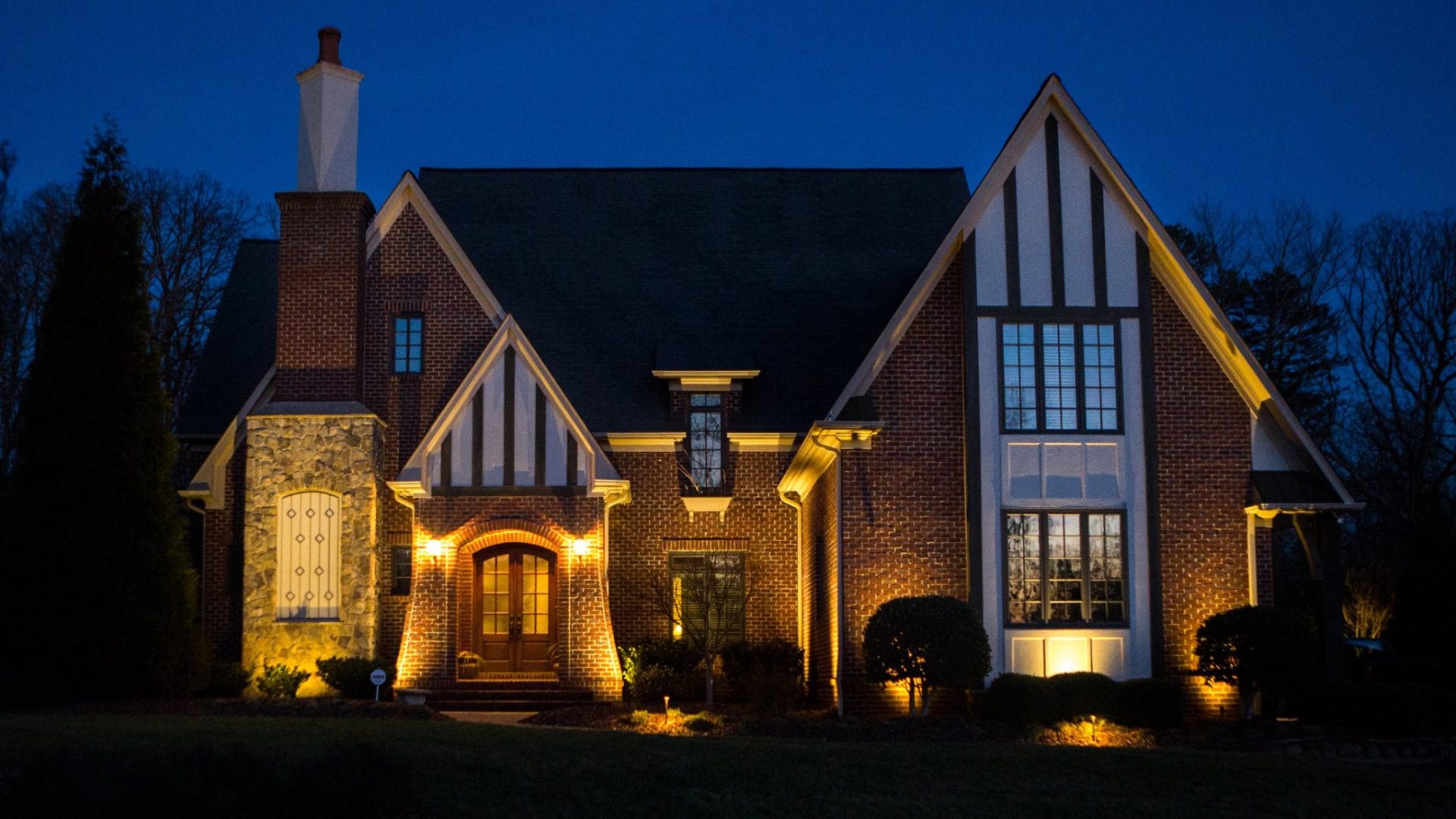 A beautiful home with outdoor lighting around the home in Greensboro, NC.
