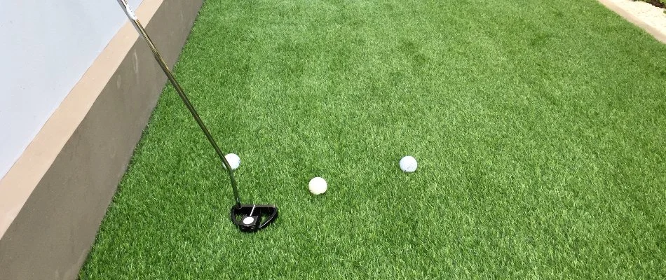 Artificial turf as a putting green in Greensboro, NC, with golf balls and club.