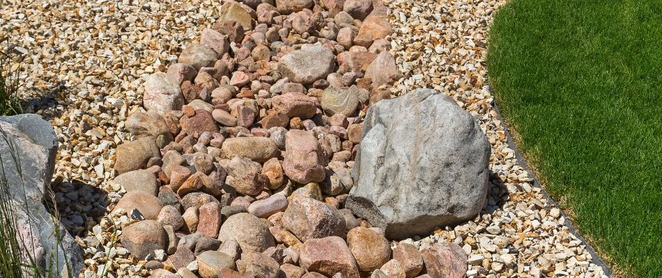 Dry creek bed in Greensboro, NC, with rocks, pebbles, and boulders.