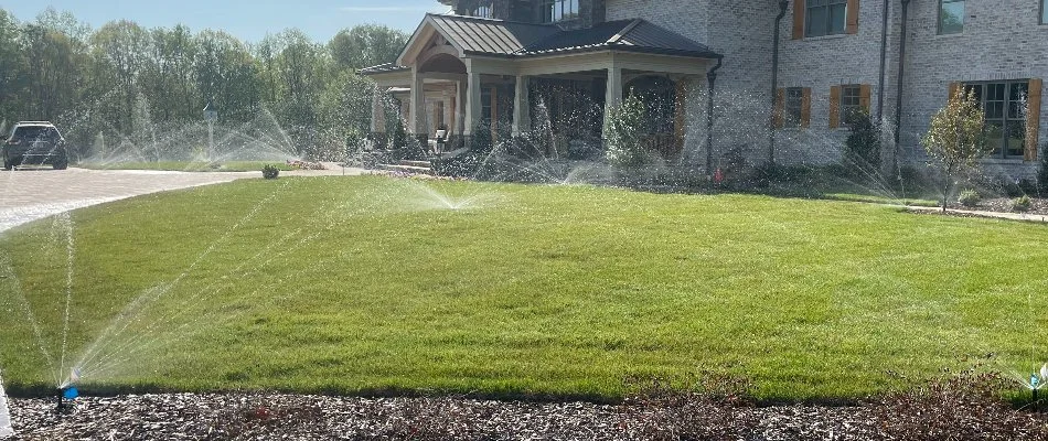 Sprinkler irrigation system spraying water on grass in Greensboro, NC.