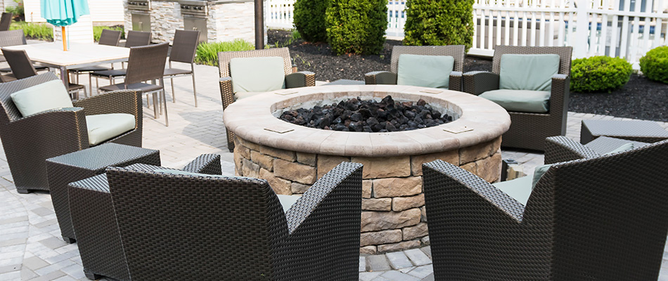 Top-tier fire pit made from stones and pavers surrounded by seating near Wallburg, NC.