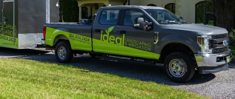 A lawn care company truck parked in front of a home in Greensboro, NC.