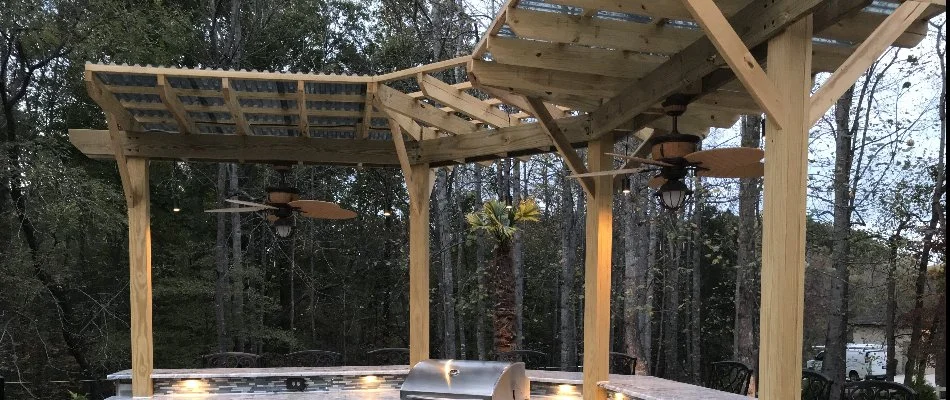 A light wood pergola over an outdoor kitchen in Greensboro, NC.