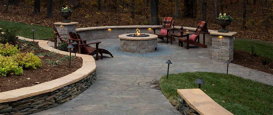 Custom walkway leading to a patio with seating walls and fire pit in Summerfield, NC.