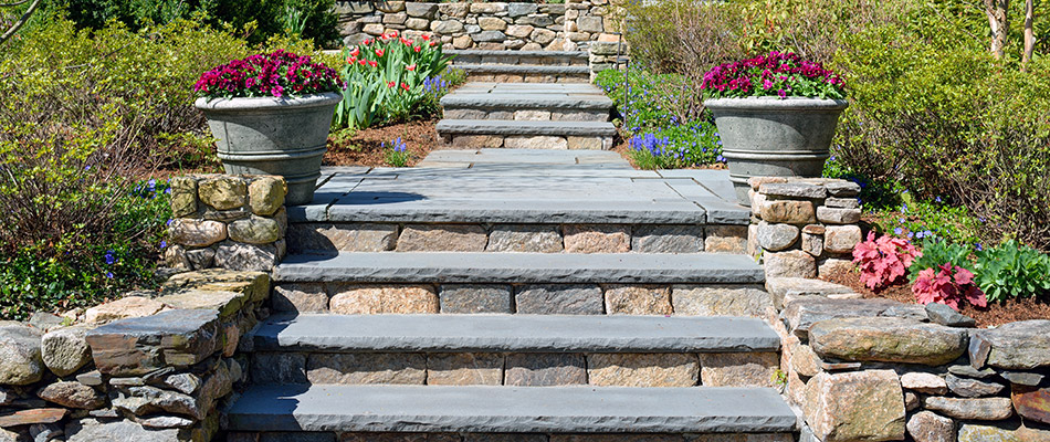 Custom stone outdoor steps surrounded by flowers and plantings in Burlington, NC. 