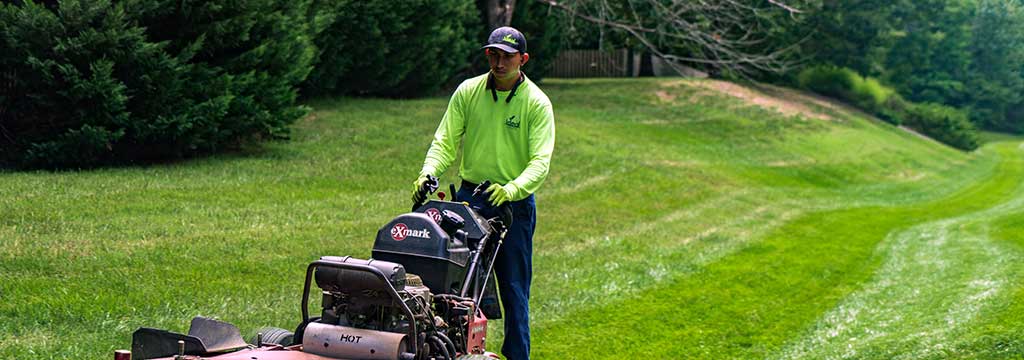 Lawn care technician on a large mower near Winston-Salem, NC.